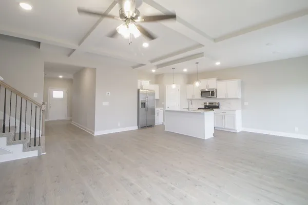 a view of an empty room and kitchen view