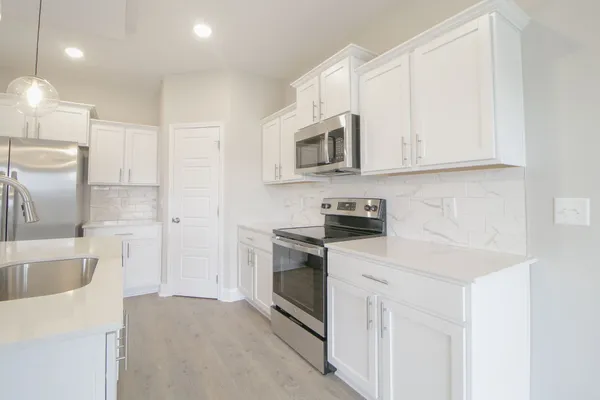 a kitchen with stainless steel appliances granite countertop a sink and a stove