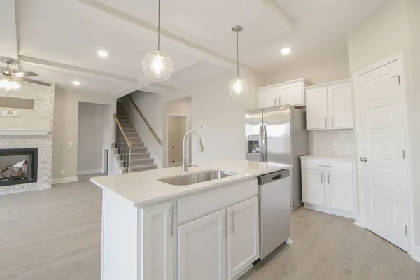 a kitchen with kitchen island a sink and a stove with wooden floor