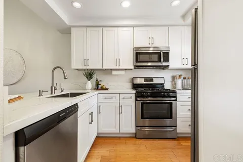a kitchen with stainless steel appliances granite countertop a stove a sink and a microwave
