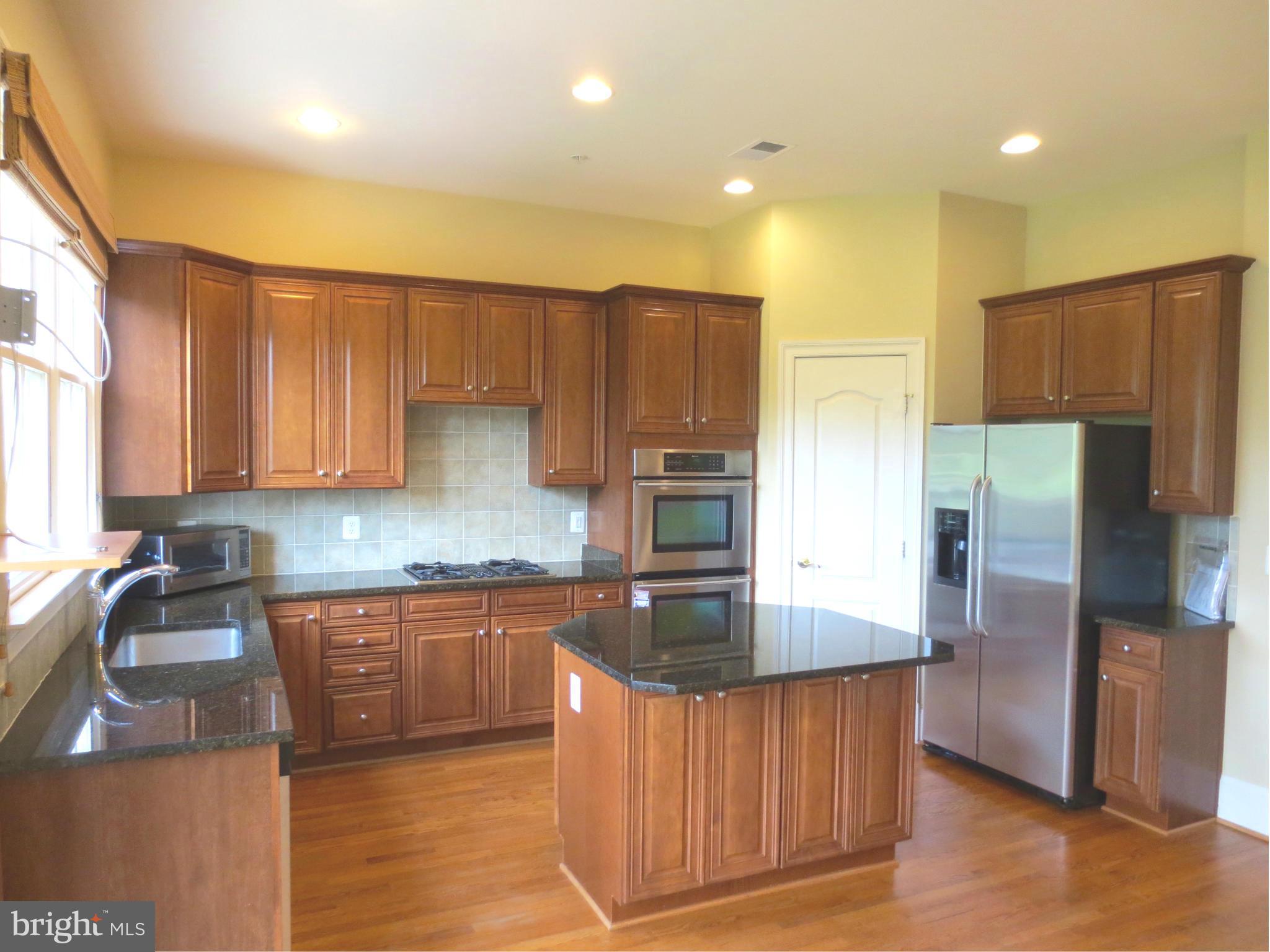 716 Carpenter Road Alexandria, VA 22314 - Photo 8 of 28 a kitchen with stainless steel appliances granite countertop a refrigerator a sink a stove a microwave and island