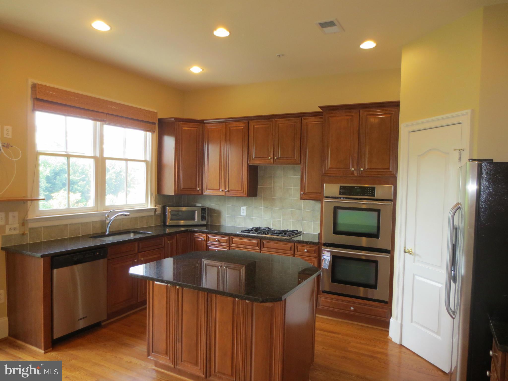 716 Carpenter Road Alexandria, VA 22314 - Photo 10 of 28 a kitchen with a sink a counter top space cabinets and stainless steel appliances