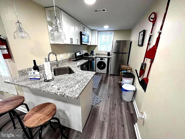 1721 McCulloh Street, Unit 3 Baltimore, MD 21217 - Photo 4 of 11 a kitchen with stainless steel appliances granite countertop a sink refrigerator and microwave