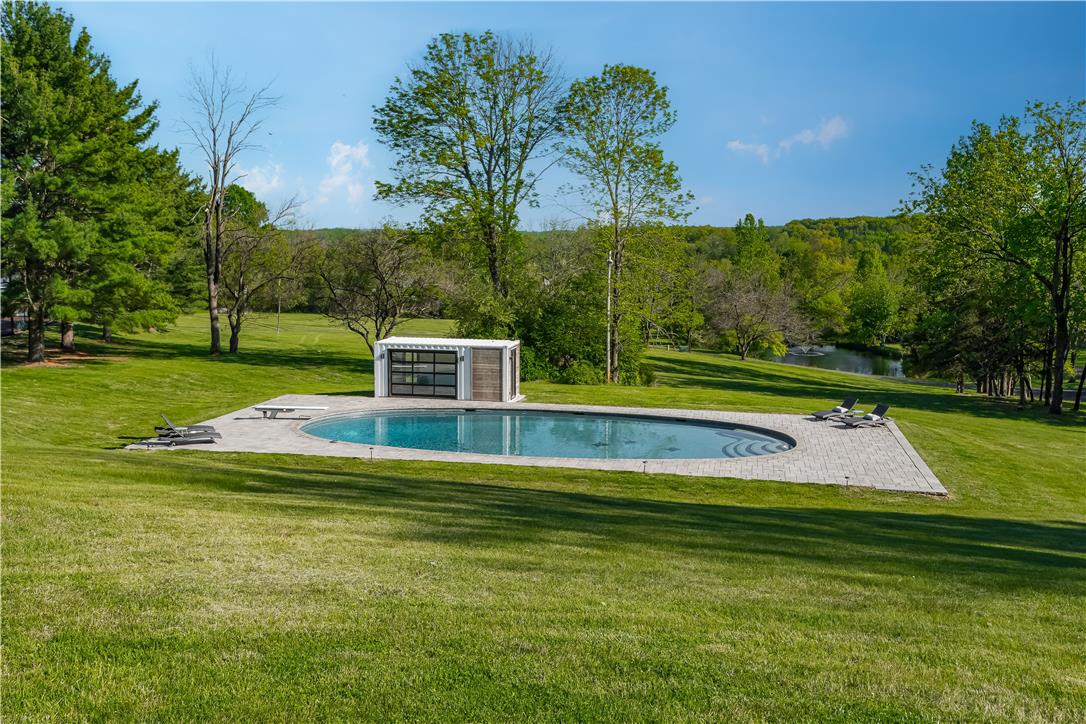 1506 Pleasant View Road Coopersburg, PA 18036 - Photo 85 of 97 An oval-shaped swimming oasis awaits, set against a backdrop of mature trees and open fields.