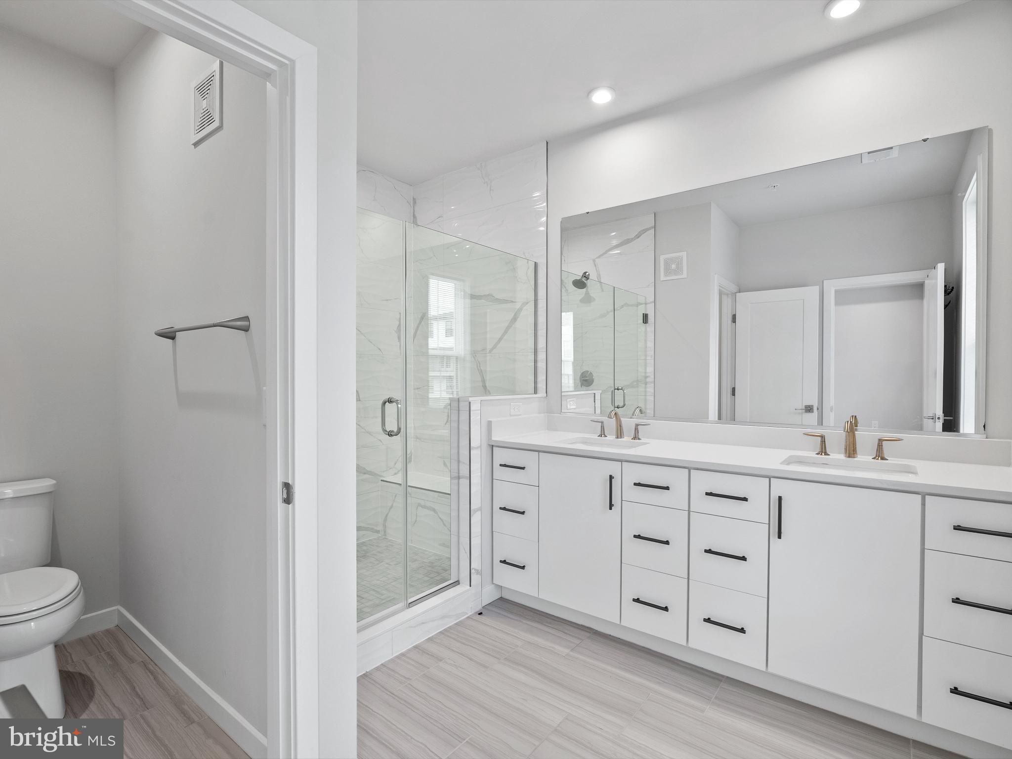 7465 Backett Wood Terrace, Unit 1215 McLean, VA 22102 - Photo 12 of 23 a spacious bathroom with a double vanity sink a toilet and a shower