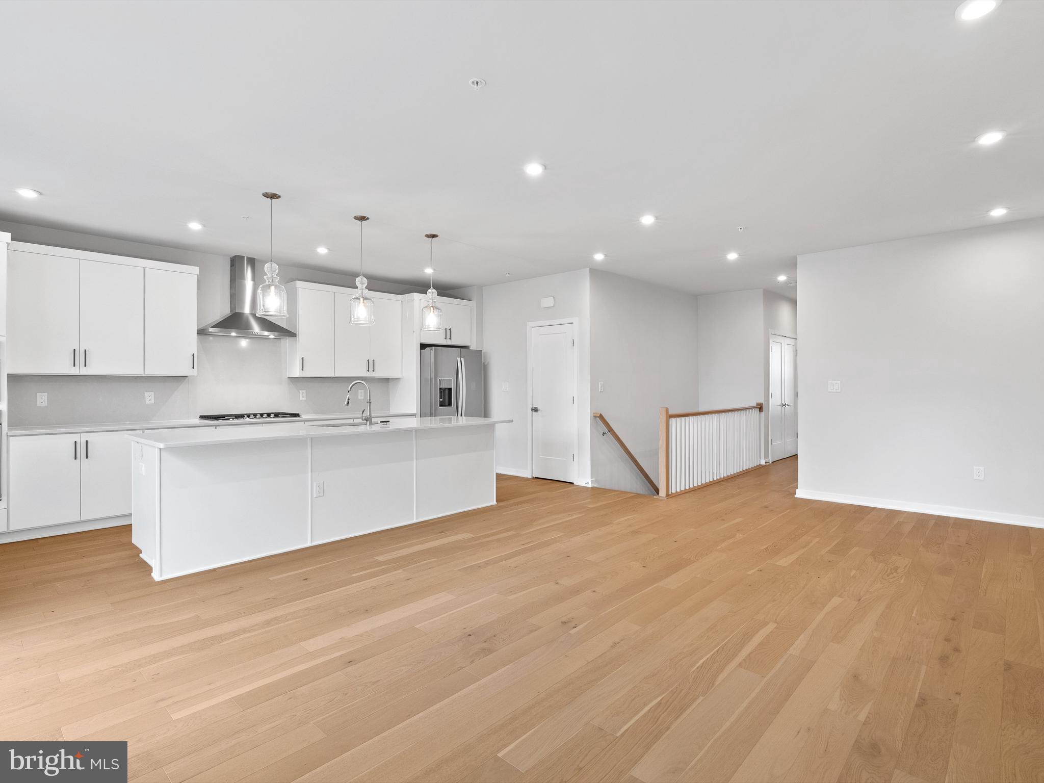 7465 Backett Wood Terrace, Unit 1215 McLean, VA 22102 - Photo 3 of 23 a large white kitchen with kitchen island a sink a center island stainless steel appliances and a cabinets