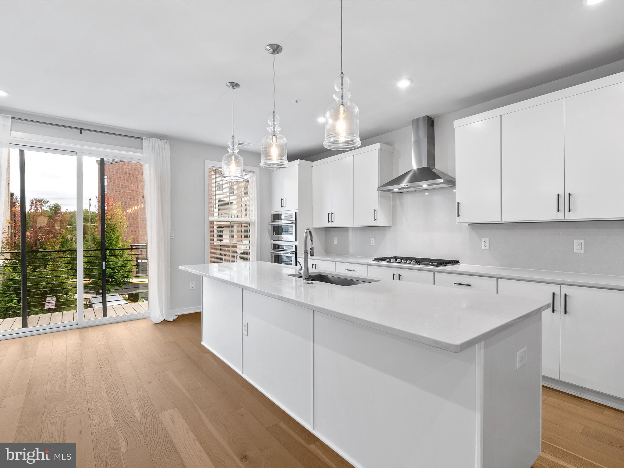 7465 Backett Wood Terrace, Unit 1215 McLean, VA 22102 - Photo 6 of 23 a kitchen with stainless steel appliances granite countertop a sink a stove a refrigerator and white cabinets with wooden floor