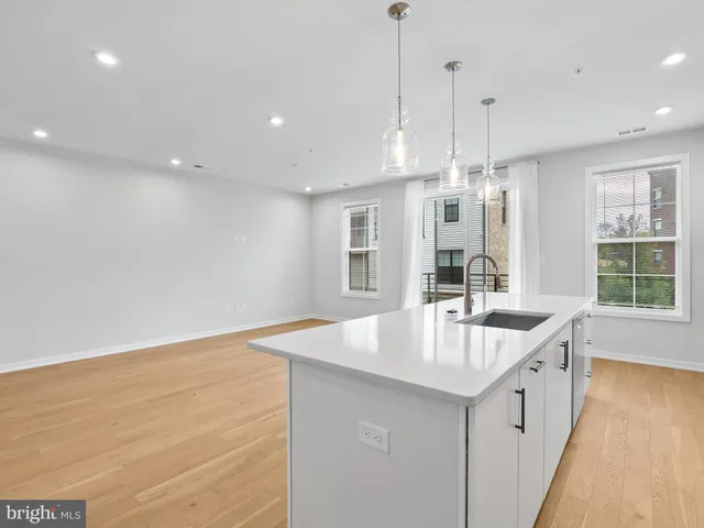 a large kitchen with kitchen island a large island a sink stainless steel appliances and cabinets