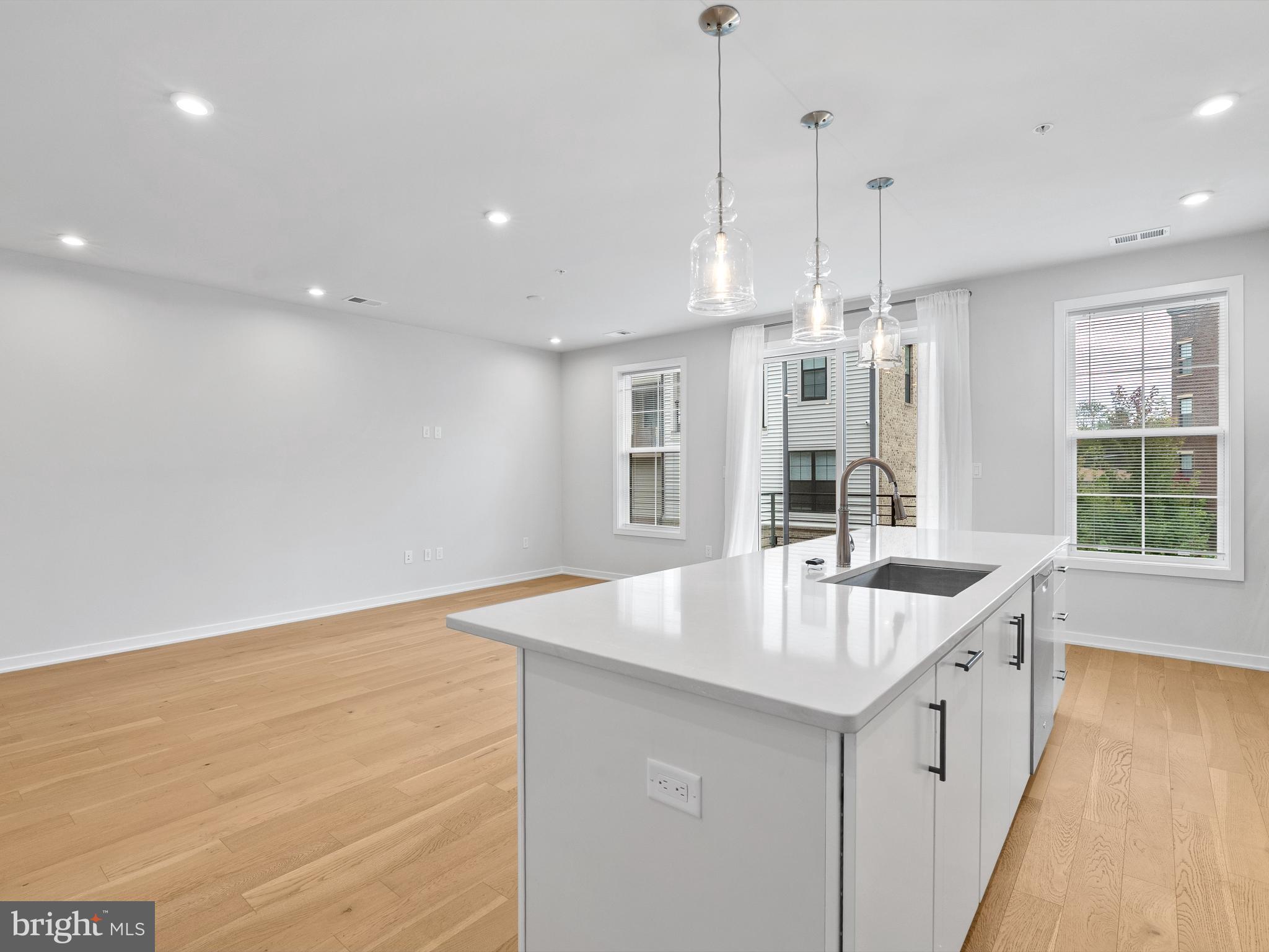 7465 Backett Wood Terrace, Unit 1215 McLean, VA 22102 - Photo 7 of 23 a large kitchen with kitchen island a large island a sink stainless steel appliances and cabinets