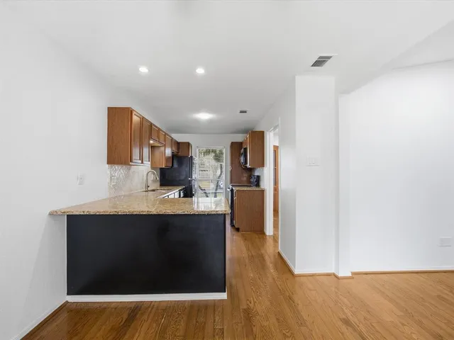 a kitchen with stainless steel appliances granite countertop a refrigerator stove microwave and sink