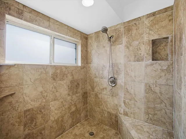 a bathroom with a granite countertop toilet sink shower and mirror