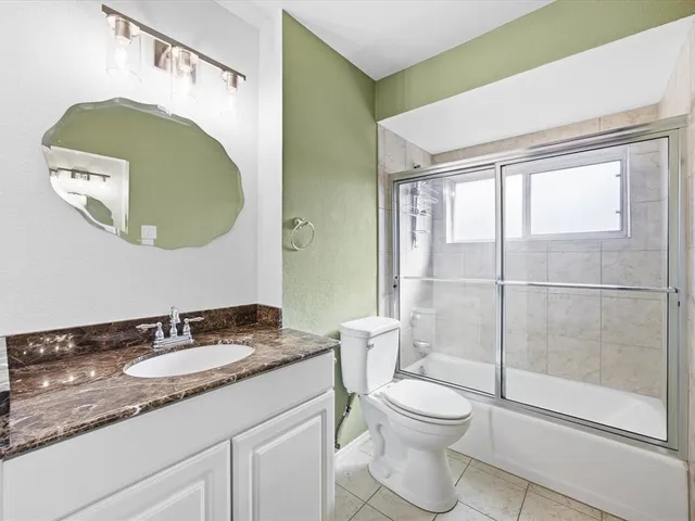 a spacious bedroom with a bed and a chandelier