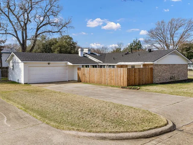 a front view of a house with a yard and trees