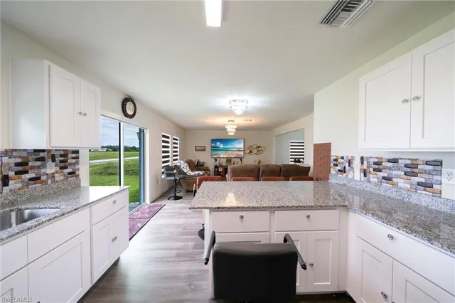 a kitchen with kitchen island granite countertop a sink counter top space and cabinets