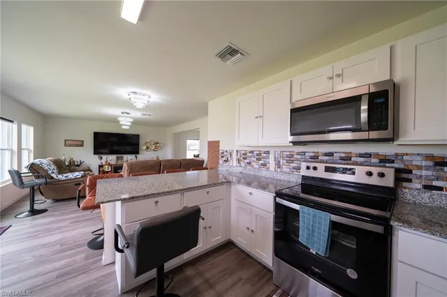 a kitchen with stainless steel appliances a stove a microwave a sink and cabinets
