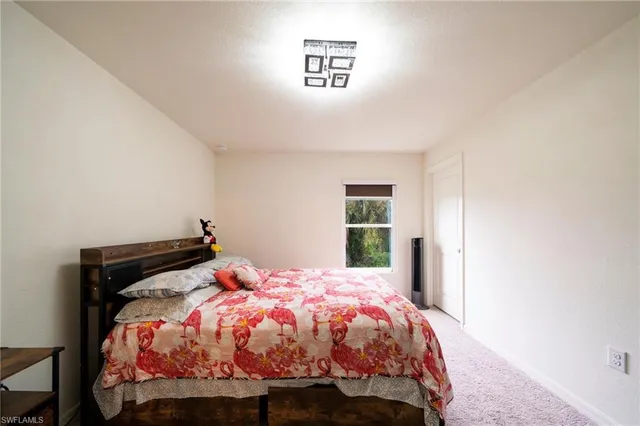 a bed sitting in a bedroom next to a window