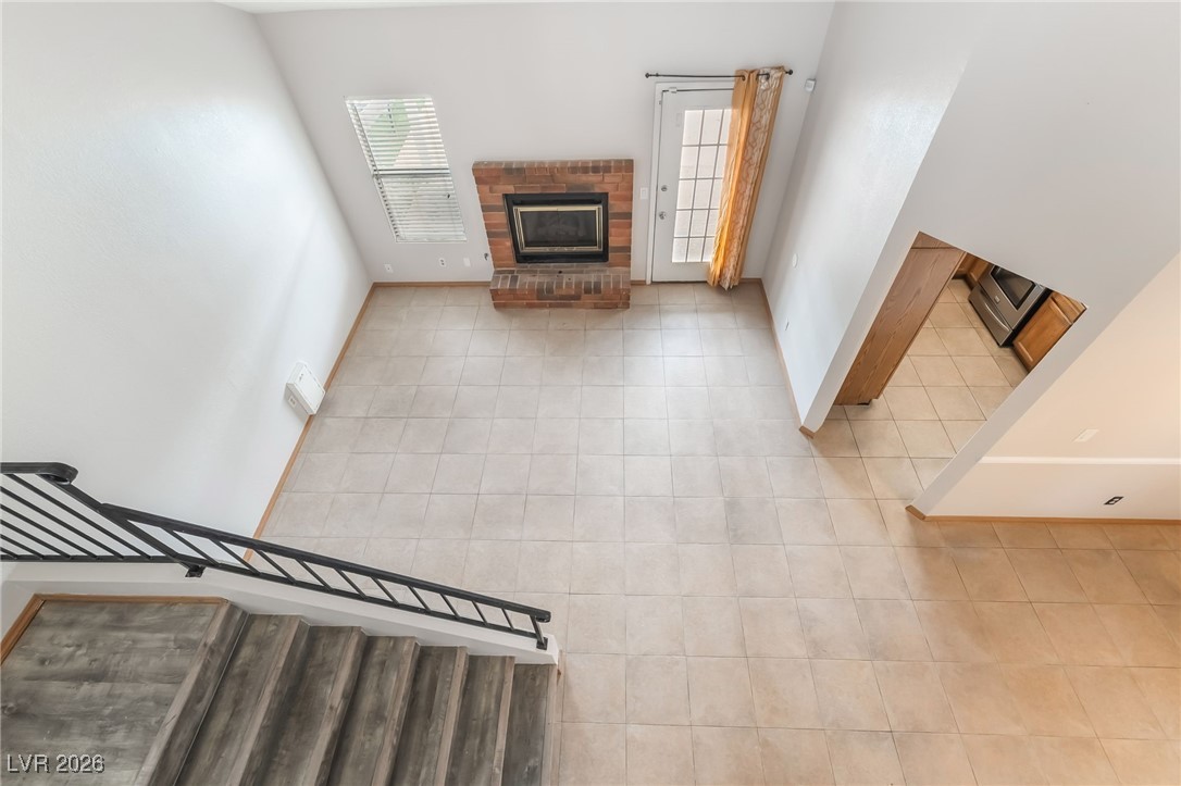 516 Inness Avenue Henderson, NV 89011 - Photo 20 of 42 Unfurnished living room featuring a brick fireplace and tile patterned floors