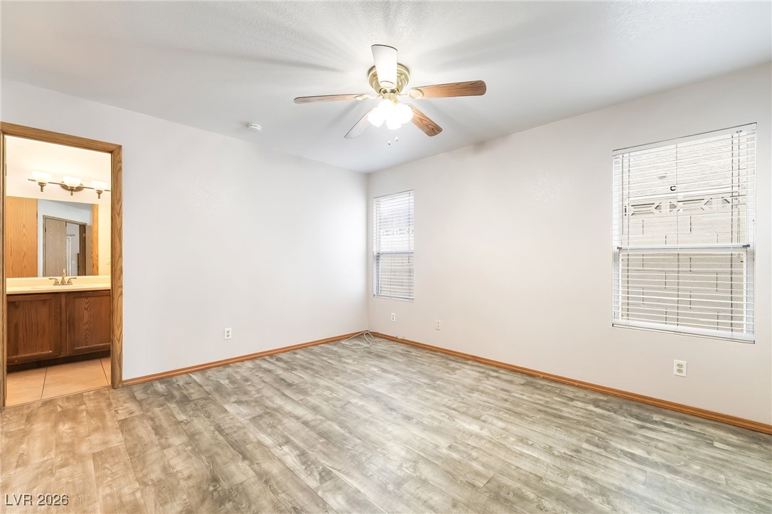 516 Inness Avenue Henderson, NV 89011 - Photo 22 of 42 Unfurnished bedroom featuring light wood-style flooring, a ceiling fan, and connected bathroom