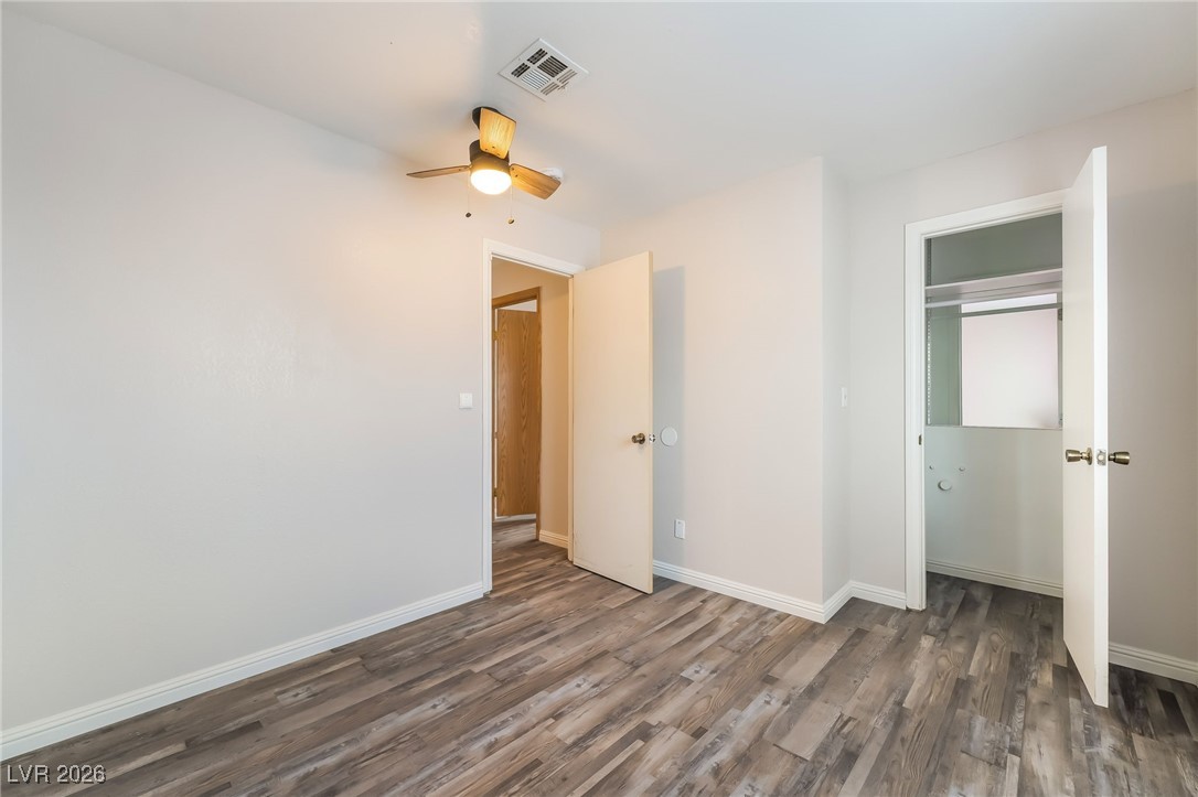 516 Inness Avenue Henderson, NV 89011 - Photo 29 of 42 Unfurnished bedroom with dark wood-style flooring, a closet, and a ceiling fan