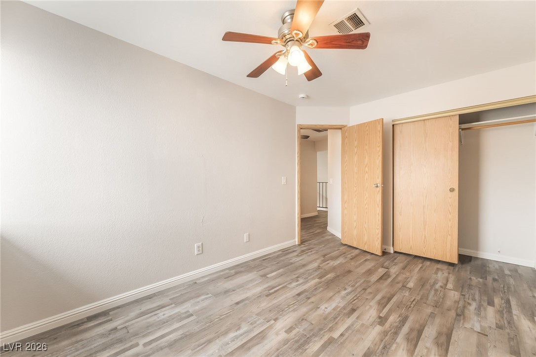 516 Inness Avenue Henderson, NV 89011 - Photo 34 of 42 Unfurnished bedroom with light wood-style flooring, ceiling fan, and a closet