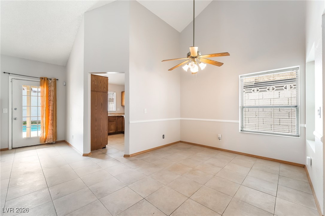 516 Inness Avenue Henderson, NV 89011 - Photo 6 of 42 Spare room with high vaulted ceiling, a ceiling fan, and light tile patterned floors