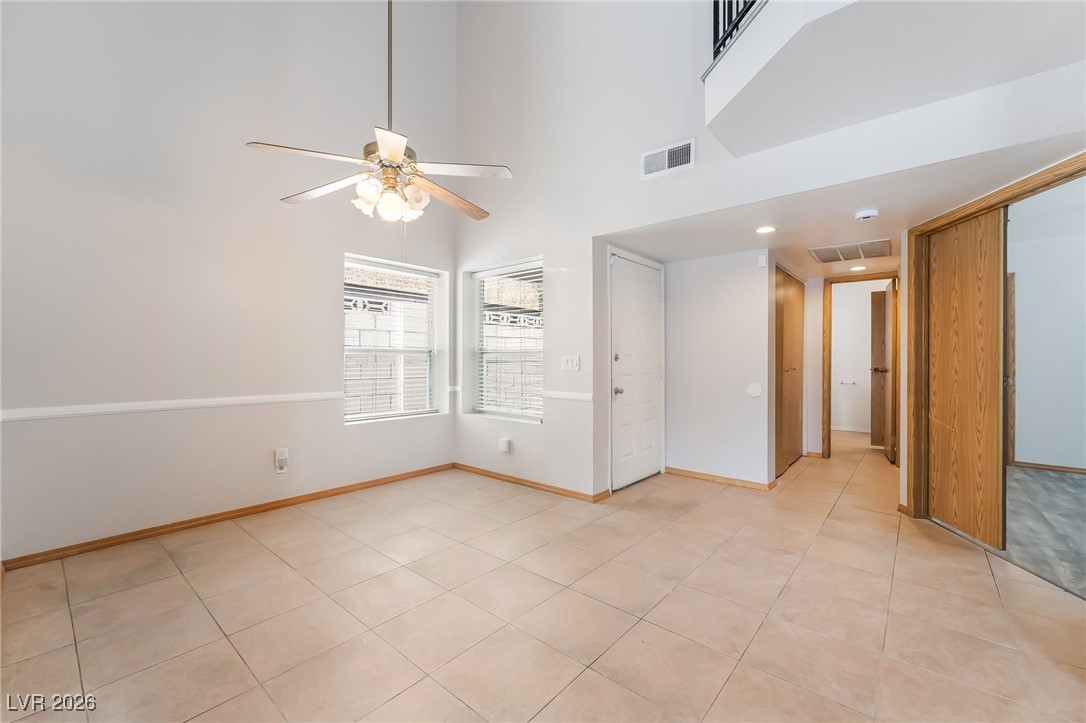 516 Inness Avenue Henderson, NV 89011 - Photo 7 of 42 Empty room with a high ceiling, a ceiling fan, and light tile patterned floors