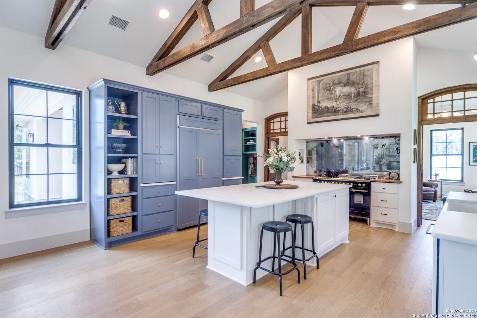 a kitchen with stainless steel appliances kitchen island a large window and cabinets
