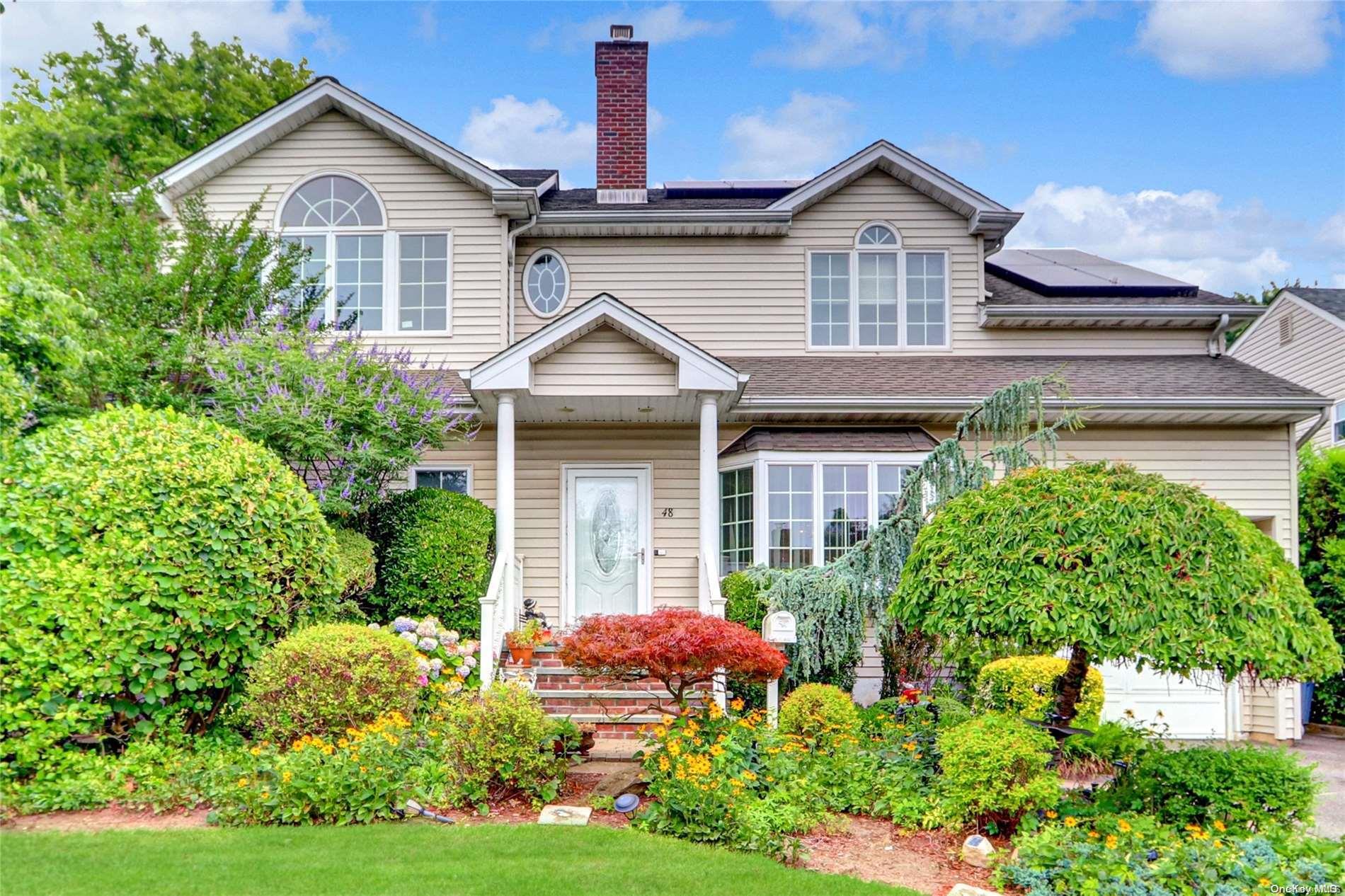 48 Chatham Road Hewlett, NY 11557 - Photo 1 of 1 a front view of a house with a yard and potted plants