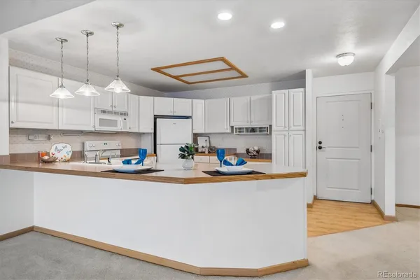 a kitchen with stainless steel appliances granite countertop a sink a stove and a refrigerator