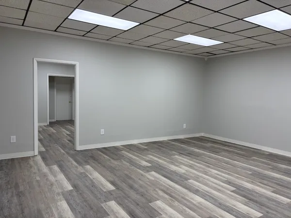 a view of an empty room with wooden floor