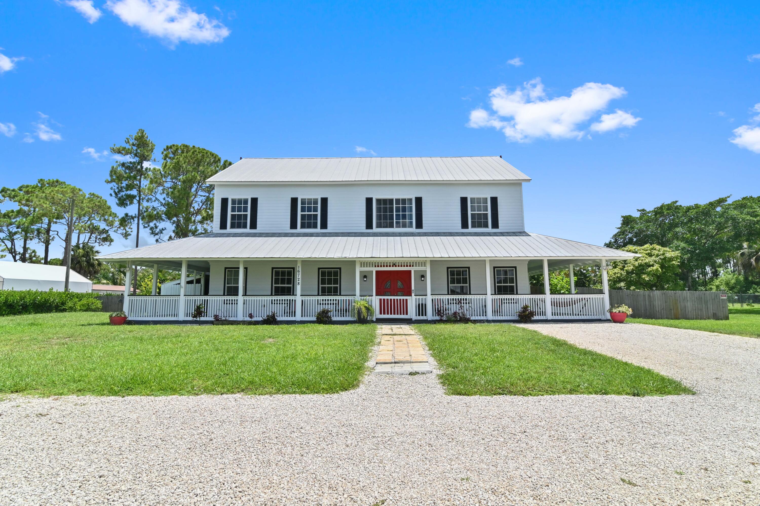 a front view of a house with a yard and potted plants