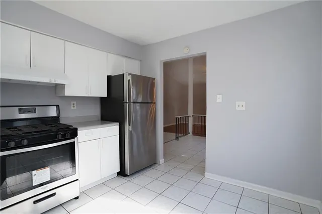 a kitchen with a refrigerator and a stove top oven