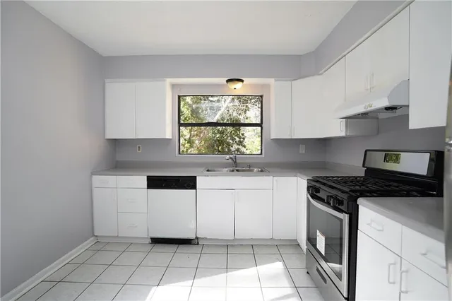 a kitchen with a stove a sink and a window