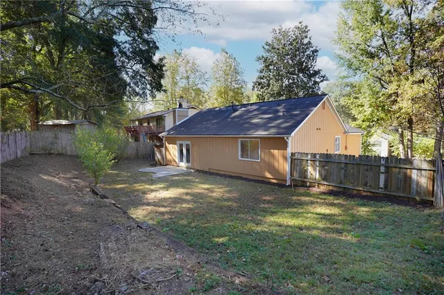 a view of a yard in front of a house with large trees