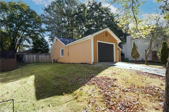 a wooden house with a large tree in front of it