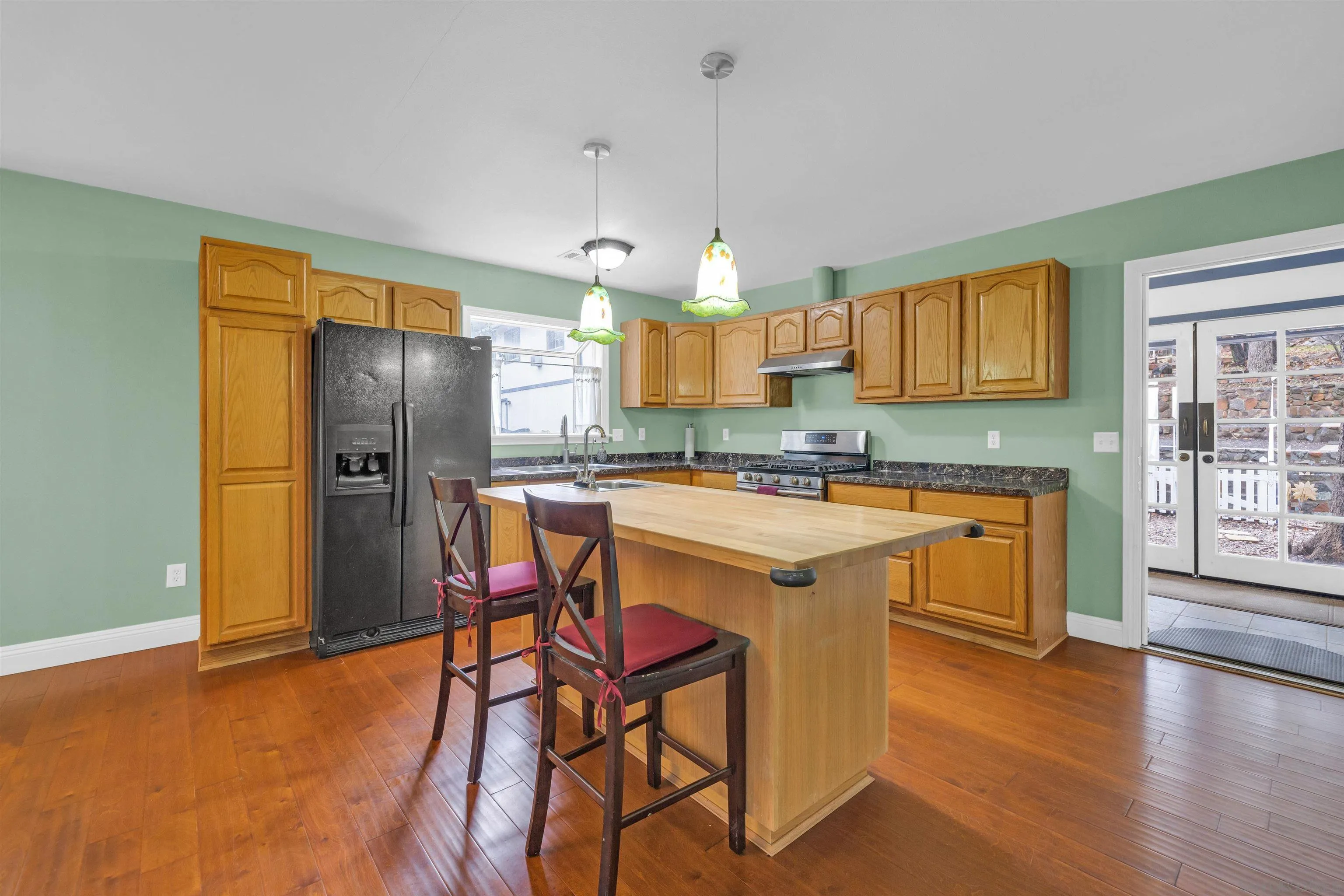 17009 Iron Springs Road Julian, CA 92036 - Photo 14 of 70 a kitchen with stainless steel appliances granite countertop a refrigerator a sink dishwasher a stove and a dining table with wooden floor