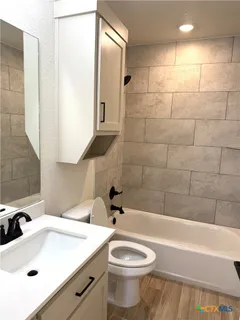 a bathroom with a sink a toilet and bathtub