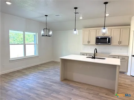 a kitchen with kitchen island a sink and a wooden floor