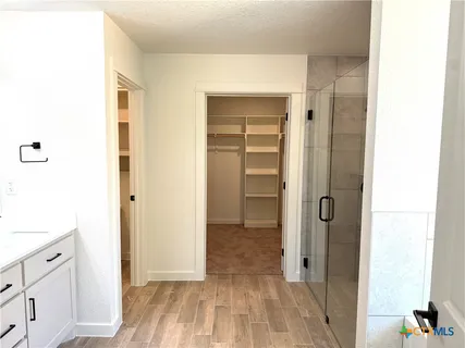 a view of a hallway with wooden floor