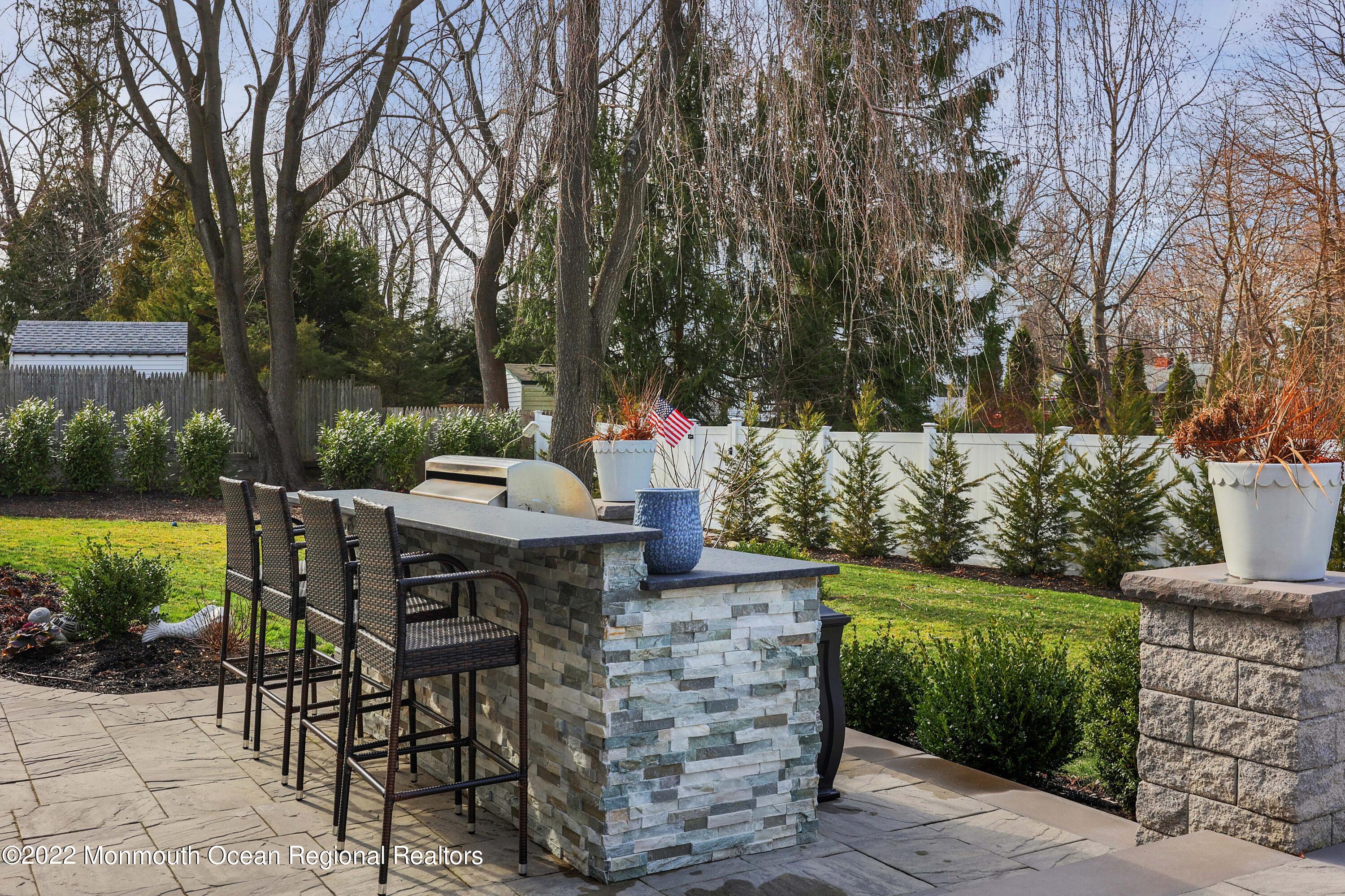 47 Shadowbrook Road Shrewsbury, NJ 07702 - Photo 31 of 39 a view of a patio with table and chairs under an umbrella