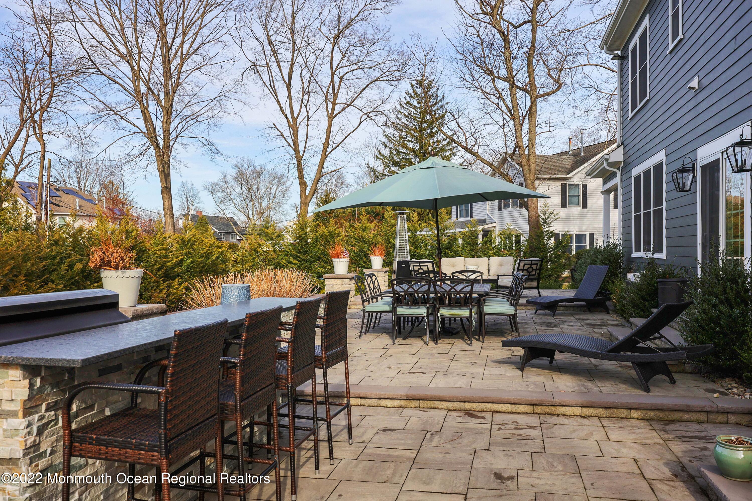 47 Shadowbrook Road Shrewsbury, NJ 07702 - Photo 33 of 39 a view of a patio with table and chairs under an umbrella