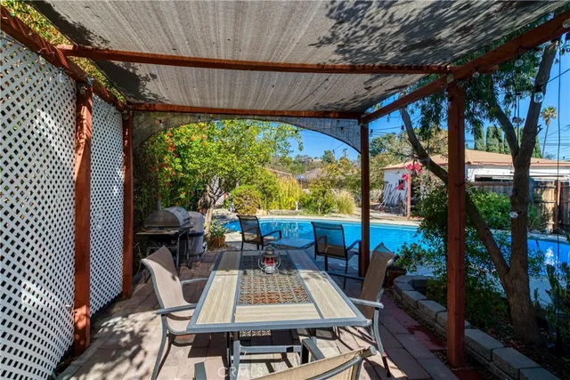 a view of a patio with table and chairs potted plants and floor to ceiling window