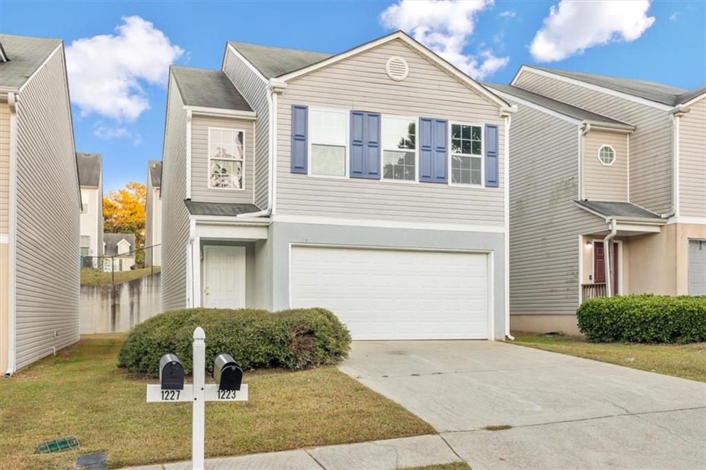 1223 Brookstone Road Atlanta, GA 30349 - Photo 1 of 1 View of front of home featuring a garage and a front yard