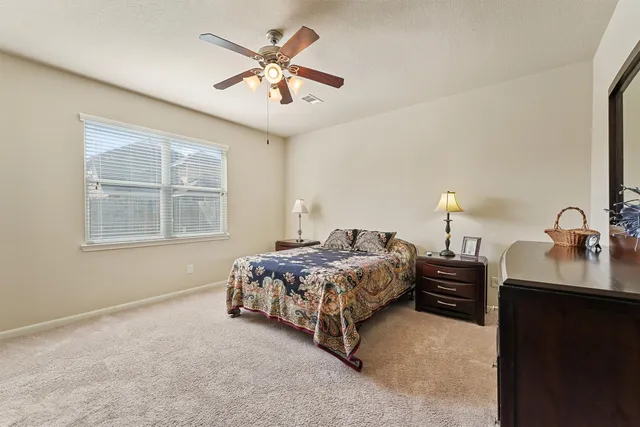 a bedroom with a bed chandelier and a window
