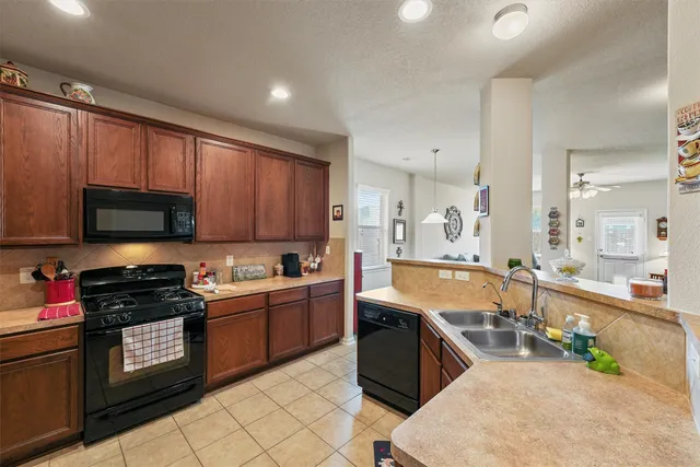 a large kitchen with stainless steel appliances granite countertop a stove sink and cabinets