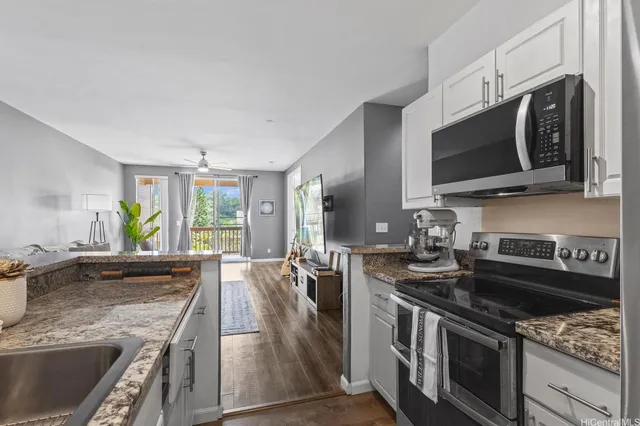 a kitchen with stainless steel appliances granite countertop a sink stove and microwave