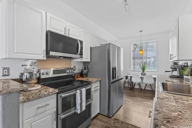 a kitchen with granite countertop a stove sink and refrigerator