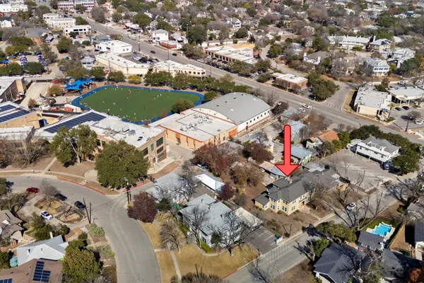 an aerial view of a house with a yard and parking spaces