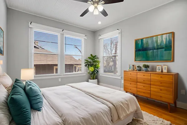 a bedroom with a large bed and a flat tv screen on dresser