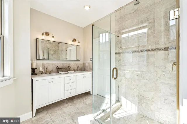 a bathroom with a granite countertop sink mirror and shower